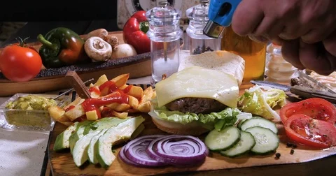 Melting cheese over a burger using a blow torch Stock Footage 73737122