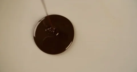 Melting Chocolate flows on white surface 4K sweet video Stock Footage 102620958