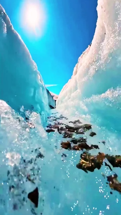 Melting glacier ice stream flowing through rocky crevasse in high altitude .. 库存影片 333669849
