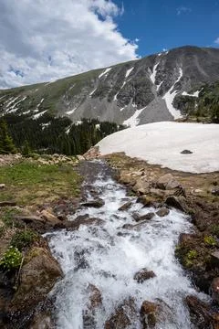 Melting glacier on Lake Isabelle Trail, Colorado under sunny summer cloudscape. Stock Photos