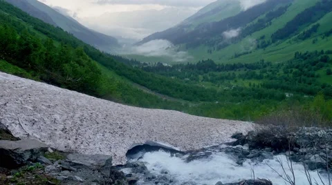 Melting of the glacier. Mountain Stream Under Ice and flowing into the valley Vídeos de archivo 65570830