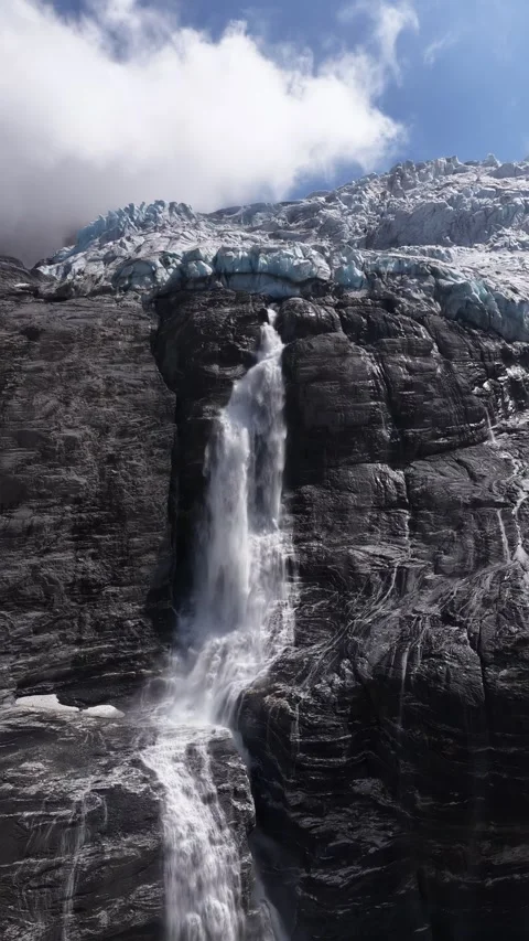 Melting glacier water falling down rocky mountain cliff, Switzerland Stock Footage 318011791