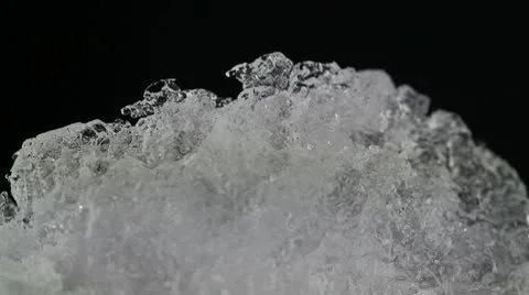 Melting ice closeup on black background. accelerated shoot Stock Footage