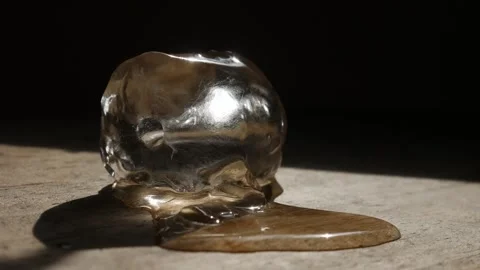 Melting ice cube on rustic wooden table surface 스톡 동영상 336665459