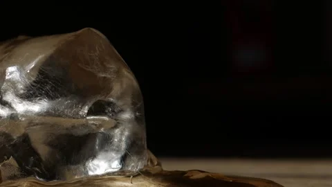 Melting ice cube on rustic wooden table surface Vidéo 337873158