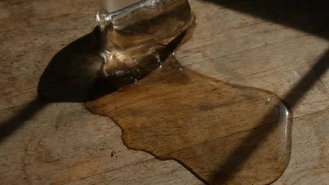 Melting ice cube with water puddle on rustic wooden table Stock Footage 336665469