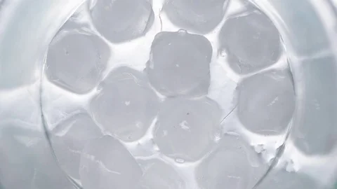Melting ice cubes from above in round glass, timelapse, 4k Stock Footage 80047451
