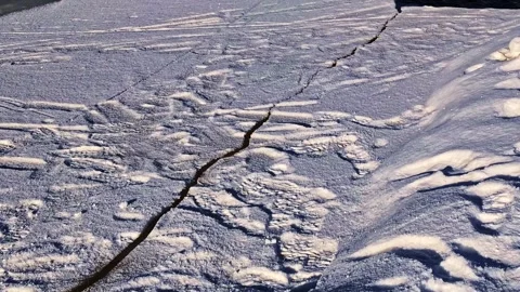 Melting ice floe cracking and breaking apart on a flowing river in late winter Stock Footage 346594388