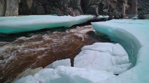 Melting ice on the flowing river surrounded by rock Stock Footage 91517708