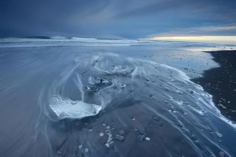 Melting ice forming patterns on a beach Stock Photos
