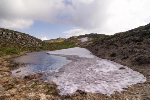 Melting ice puddle in spring mountains landscape photo Stock Photos
