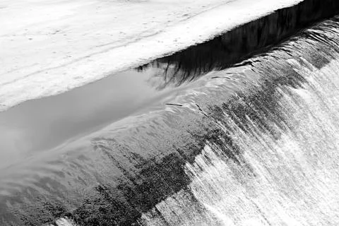 Melting ice of the river with stream of falling water Stock Photos