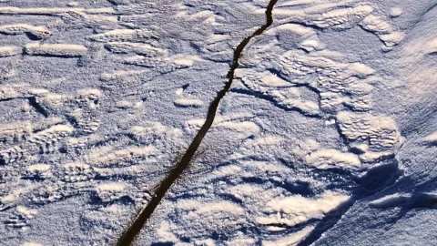 Melting ice sheet cracking on a flowing blue river in winter season Stock Footage 332947814