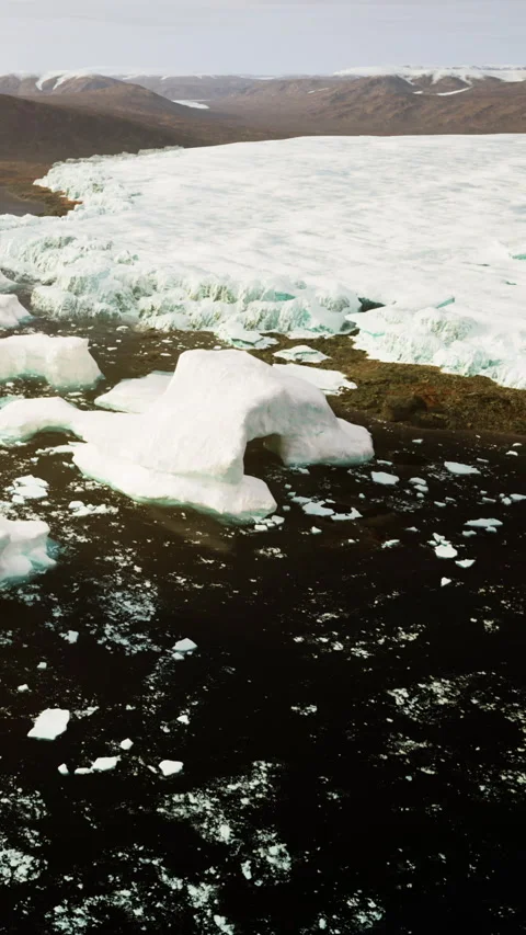 Melting icebergs floating in the water under a clear sky in the Arctic Stock Footage 339418751