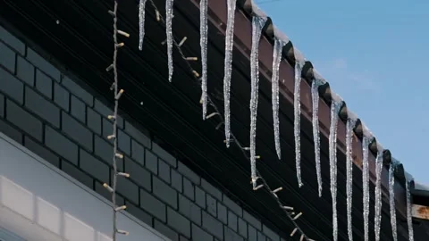 Melting Icicles Drip From Rooftop on a Sunny Winter Day Stock Footage 325436807