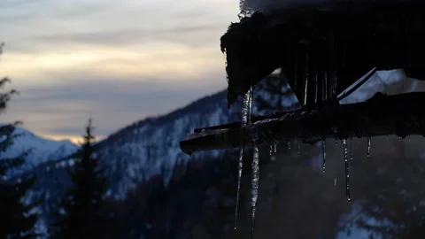 Melting icicles in front of mountain sunset Video stock 145911774