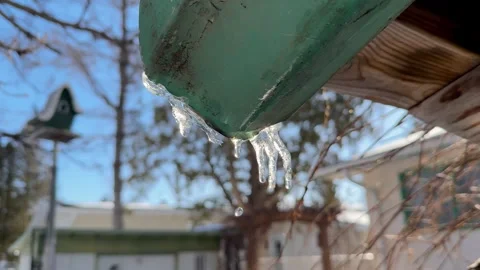 Melting icicles on a gutter in spring Stock Footage 303173152