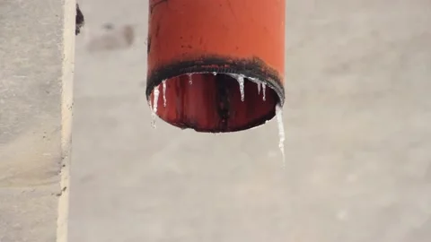Melting icicles on a plastic drainage pipe Stock Footage 221715768