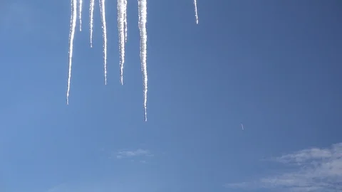 Melting icicles in spring winter against blue sky Stock Footage 87911242