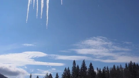 Melting icicles in spring winter against blue sky adn fir forest Stock Footage 87911307