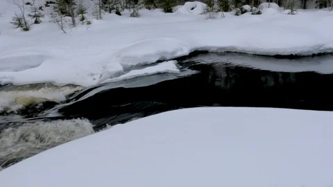 Melting river stream crosses thick snow layer close view Stock Footage 109499484