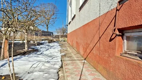 Melting Snow and Spring Shadows by the Garden Wall Video stock 330989743