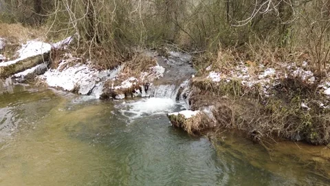 Melting-snow-creates-waterfall-iinto-stream Stock-Footage 337129622