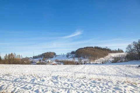 Melting snow on the fields in early spring against the blue sky. Stock Photos