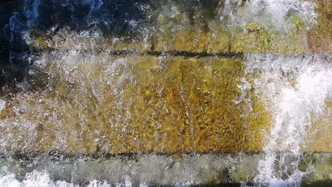 Melting snow in the mountains, fast streams of cold clear ice water flow through Stock Footage 327138641