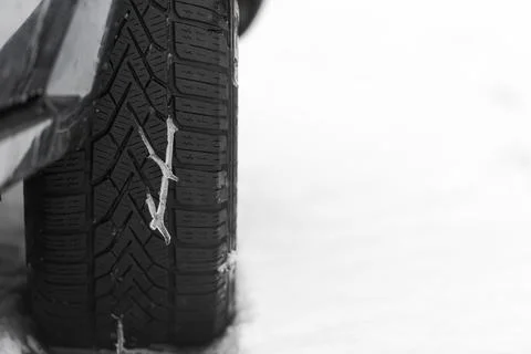 Melting snow in tread pattern of winter tire on car with snow and free space  Foto stock