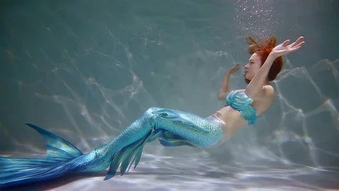 Memaid is floating on her back in water. Stock Footage 84793939