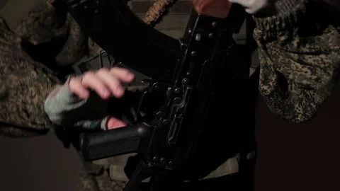 A member of the Armed Forces reload a Kalashnikov assault rifle in his hands Stock Footage 229514651