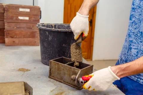 A member of the construction of the laboratory takes a sample of concrete. He Stock Photos
