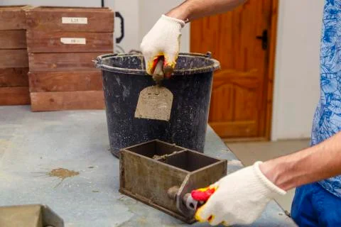 A member of the construction of the laboratory takes a sample of concrete. He Stock Photos