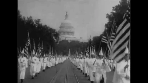 Members of the Ku Klux Klan, wearing glory suits, parade, with American flags, Stock Footage