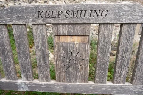 Memorial Bench with "KEEP SMILING" Carving and Sunburst Stock Photos