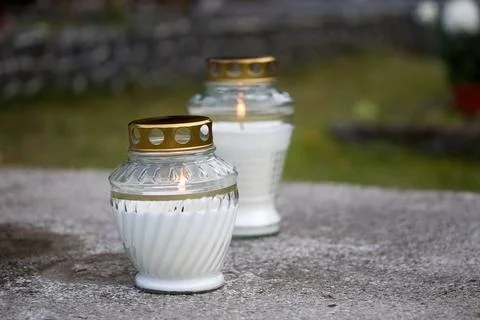 Memorial Candles. Two glass candles with golden lids on a concrete surface 스톡 사진
