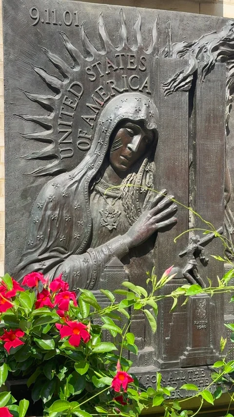 A memorial statue of the Virgin Mary embracing the World Trade Center towers Stock Footage 345155607