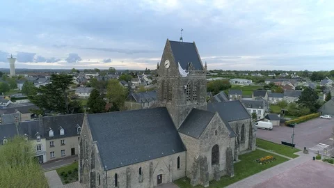 Memorial statue of world war d-day soldier stuck on side of church, Dolly Stock Footage 119647096