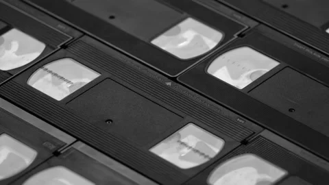 Memories evoking background of real VHS cassettes sliding up, black and white Stock Footage 155883575