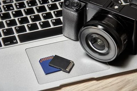 The memory cards and the camera are lying on the laptop Stock Photos
