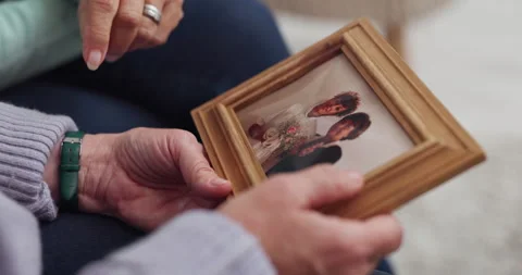 Memory, frame picture and senior hands talking and bonding due to grief after Stock Footage 246452473
