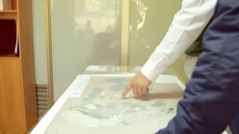 Men analyzing building plans Stock Footage 77046675