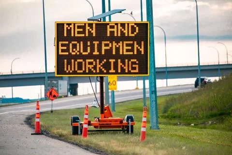 Men and equipment working Variable sign Fotos de archivo