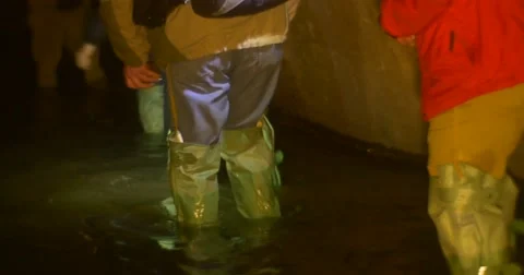 Men Approaches to an Old Pipe Light The Tube Knee-Deep Underground River Men Stock Footage 58722885