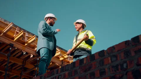 Men, architect and discussion with foreman for construction planning or Stock Footage 336221095