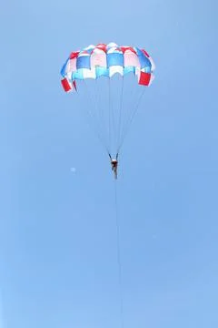 Men are gliding using a parachute on the background of the blue sky. Stock Photos