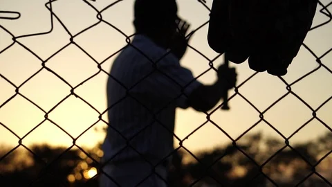 Men are hitting the baseball player with the sunset Stock Footage 121239116