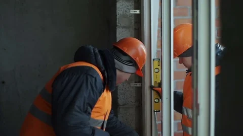 Men are installing a plastic window Stock Footage 82296252