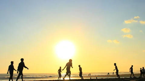Men are Playing a Game of Beach Soccer or Football - Silhouette at Sunset Stock Footage 38916576